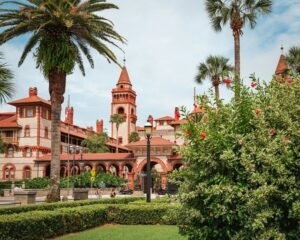 A large building with a clock tower next to a lush green park