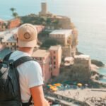 a man with a backpack looking at the ocean